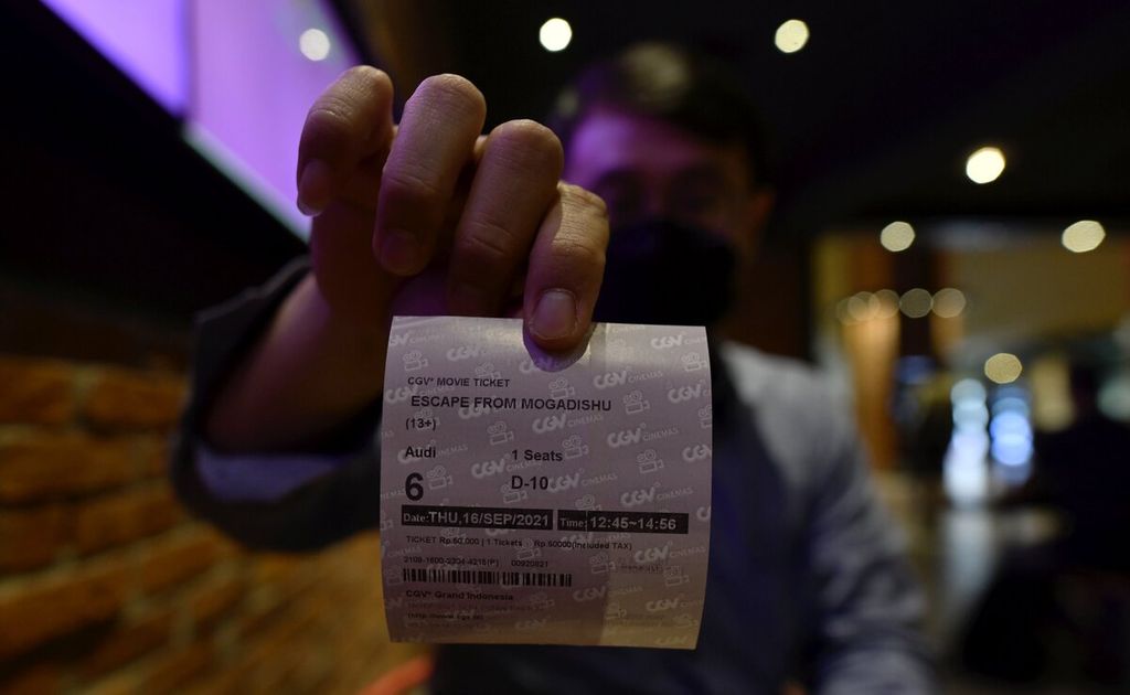 Pengunjung menunjukan tiket film yang akan ditonton di salah satu jaringan bioskop CGV di Jakarta, Kamis (16/9/2021). 