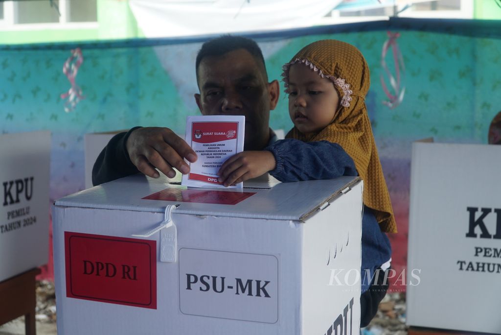 Warga dibantu anaknya memasukkan surat suara yang sudah dicoblos ke dalam kotak dalam pemungutan suara ulang (PSU) anggota DPD RI Dapil Sumatera Barat (Sumbar) di TPS 9 Kelurahan Sawahan, Kecamatan Padang Timur, Kota Padang, Sumbar, Sabtu (13/7/2024). 