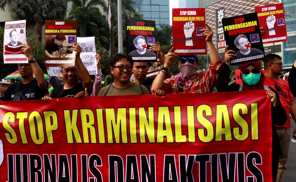 Sejumlah jurnalis melakukan aksi berjalan mundur saat menggelar aksi solidaritas di kawasan Hari Bebas Kendaraan Bermotor, Bundaran Hotel Indonesia, Jakarta, Minggu (29/9/2019). 