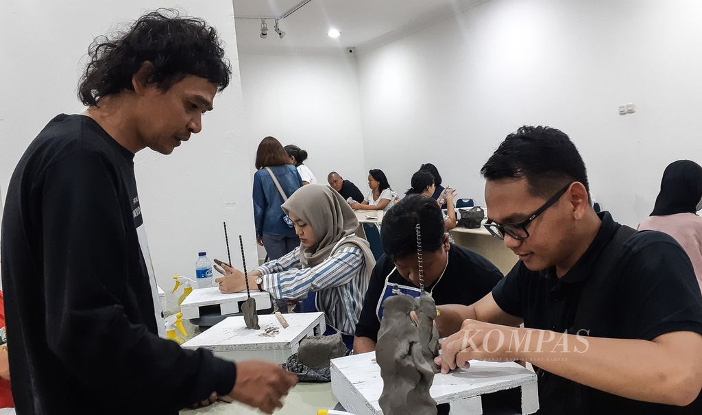 Perupa Budi Santoso (kiri) mendampingi peserta lokakarya patung, lukis, dan cukil di Galeri Nasional, Jakarta, Sabtu (27/7/2024). Lokakarya ini merupakan rangkaian pameran Patung dan Aktivisme: Dolorosa Sinaga dan Budi Santoso. Pameran berlangsung hingga 19 Agustus 2024.