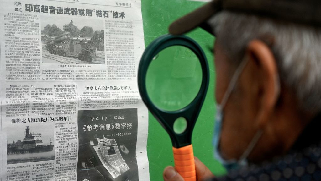 Warga China membaca berita koran di Beijing, China, tentang latihan perang militer China di Taiwan, Senin (8/8/2022). 