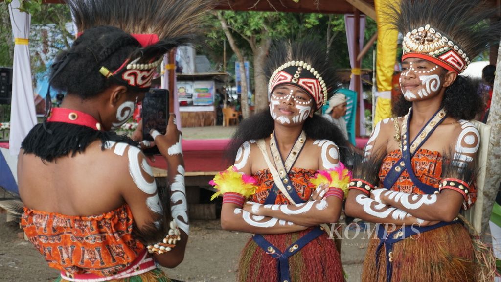 Dua perempuan muda masyarakat adat Biak Karon sedang berfoto di sela-sela acara Festival Munara Beba Byak Karon yang diselenggarakan di Kampung Werur, Distrik Bikar, Kabupaten Tambrauw, Papua Barat Daya, Jumat (24/3/2023). Festival ini diadakan untuk mengenalkan tradisi dari masyarakat adat Biak Karon kepada generasi muda.