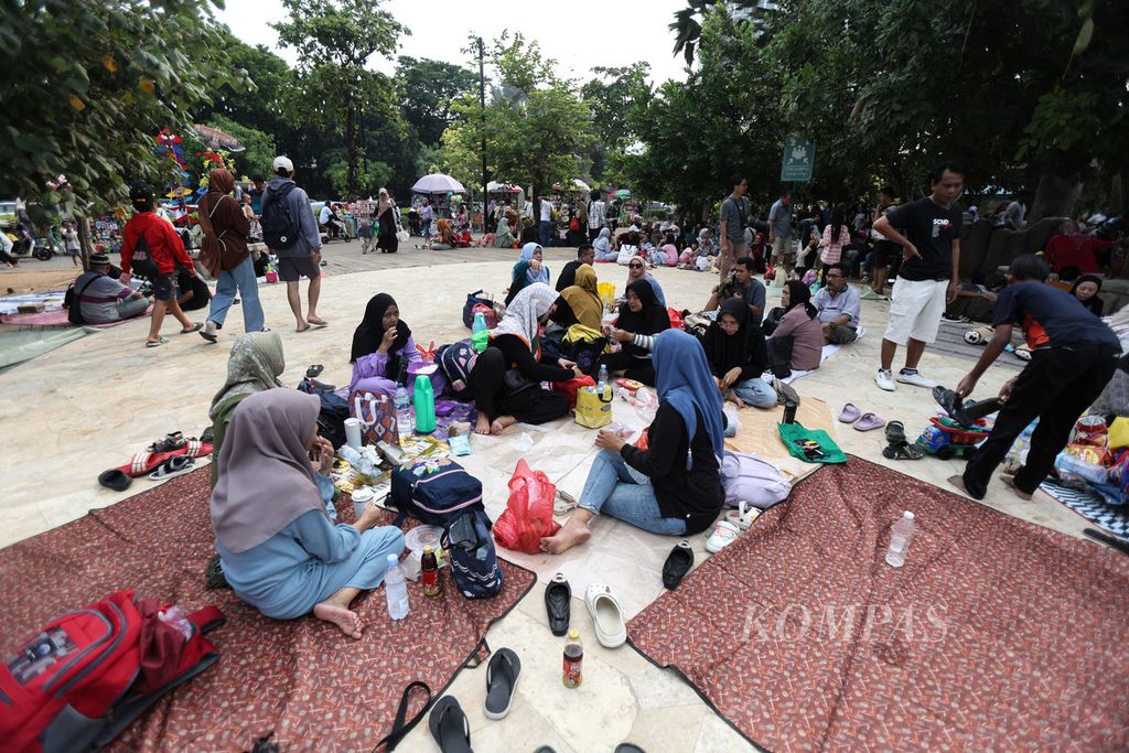 Residents spread out mats while relaxing at Ancol Beach, Jakarta, Monday (25/12/2023).
