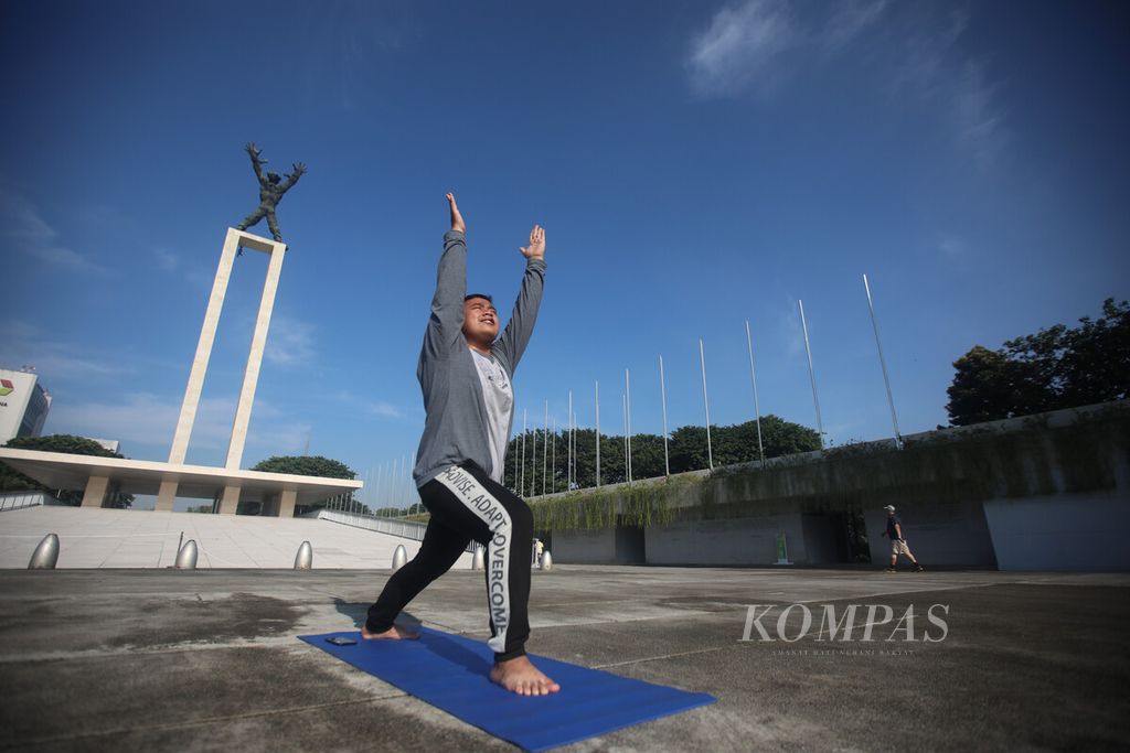 Rafi Ramadhan (20), mahasiswa perguruan tinggi negeri di Kota Malang, Jawa Timur, menikmati waktu liburnya di kampung halaman di Jakarta dengan berolahraga di kawasan Lapangan Banteng, Jakarta, Sabtu (23/4/2022). 