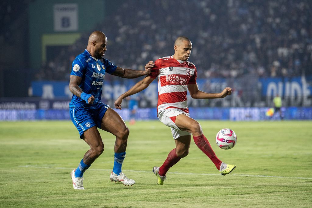 Pemain Persib Bandung, David Da Silva (kiri), berebut bola dengan  pemain Madura United, Cleberson, saat pertandingan pertama final <i>championship series </i>BRI Liga 1 di Stadion Si Jalak Harupat, Bandung, Minggu (26/5/2024). Persib menang 3-0.