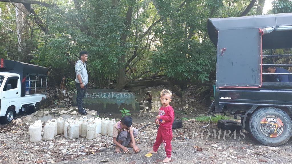 Anak-anak ikut antre mengambil air bersih di kali dekat Pos Lintas Batas Motamasin, Kabupaten Malaka, NTT, pada Senin (10/1/2022). Krisis air bersih menjadi masalah di kawasan perbatasan negara Timor Leste itu.
