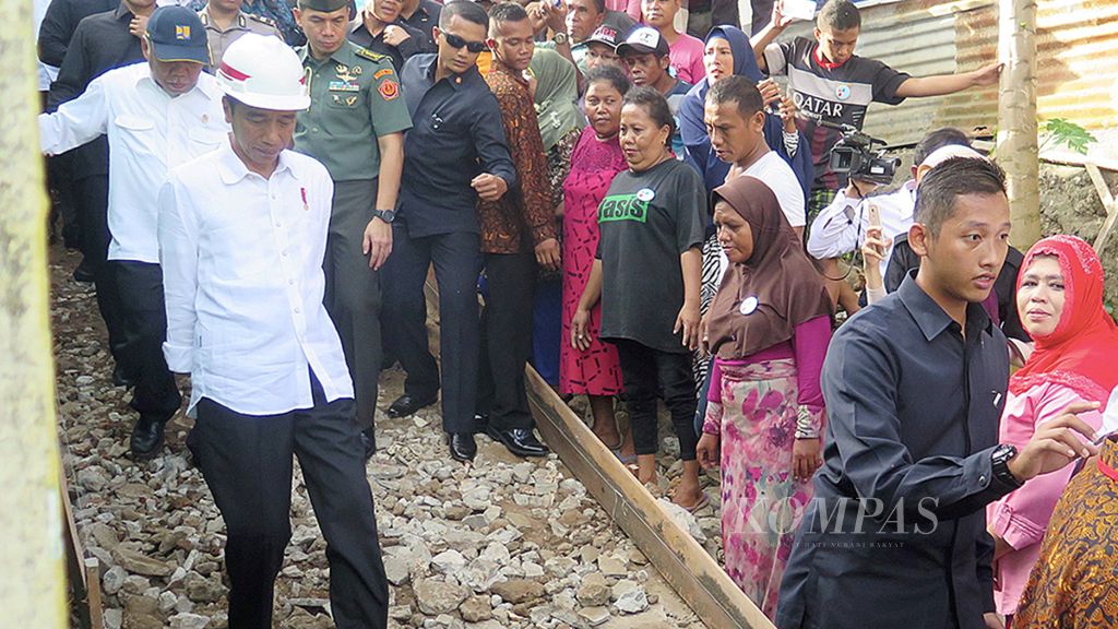 Presiden Joko Widodo (menggunakan helm putih) meniti jalan yang sedang dibangun di permukiman warga Negeri Batumerah, Kecamatan Sirimau, Kota Ambon, Provinsi Maluku, Rabu (14/2/2018).  