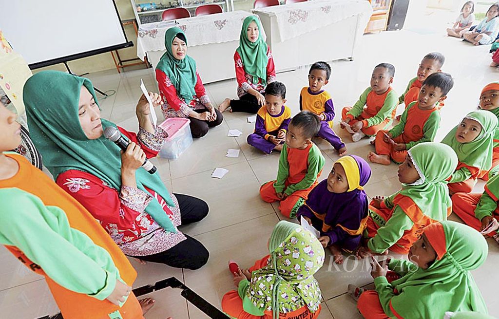 Relawan Save The Children mengarahkan sejumlah siswa taman kanak-kanak yang turut dalam permainan literasi di Pos Baca RPTRA Sunter Jaya, Jakarta Utara, Jumat (21/7). Fasilitator ruang publik, seperti RPTRA serta relawan, memegang peranan penting dalam menumbuhkan dan menggiatkan  minat baca anak-anak.