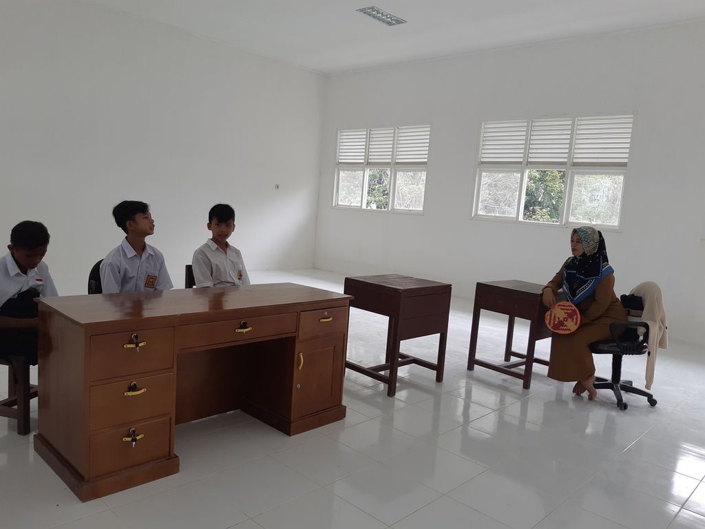 Julia Yati (38) mengajar tiga siswanya di salah satu ruangan SMPN 01 Satu Atap Peso di Desa Long Peleban, Kecamatan Peso, Kabupaten Bulungan, Kalimantan Utara, Senin (23/10/2023).