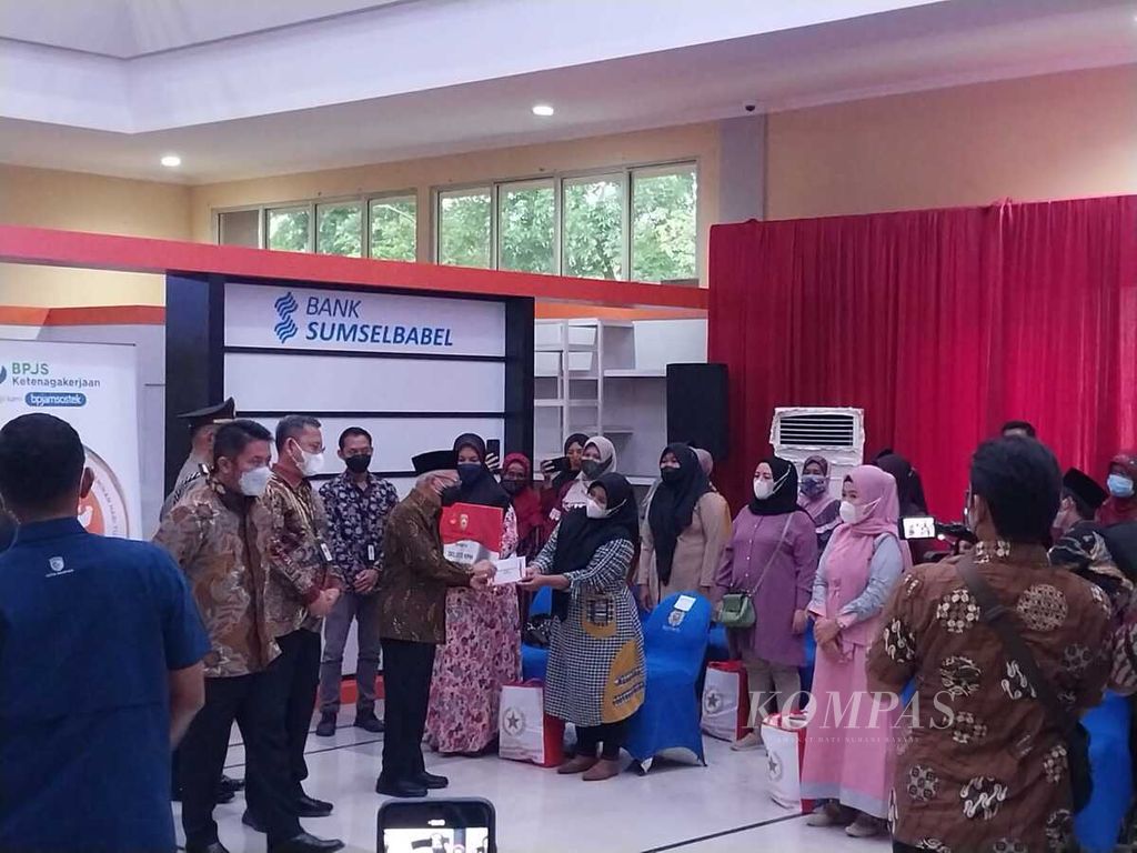 Wakil Presiden Ma'ruf Amin menyerahkan bantuan dari Kementerian Sosial dan Badan Penyelenggara Jaminan Sosial Ketenagakerjaan kepada warga di Mal Pelayanan Publik Dinas Penanaman Modal dan Pelayanan Terpadu Satu Pintu Kota Palembang, Provinsi Sumatera Selatan, Selasa (6/9/2022).