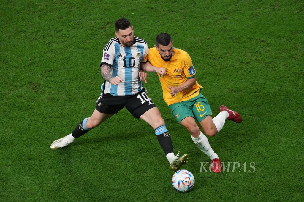 Pemain Argentina, Lionel Messi, berebut bola dengan pemain Australia, Aziz Behich, dalam pertandingan babak 16 besar Piala Dunia 2022 di Stadion Ahmad Bin Ali, Qatar, Minggu (4/12/2022) dini hari WIB. Argentina menang 2-1.