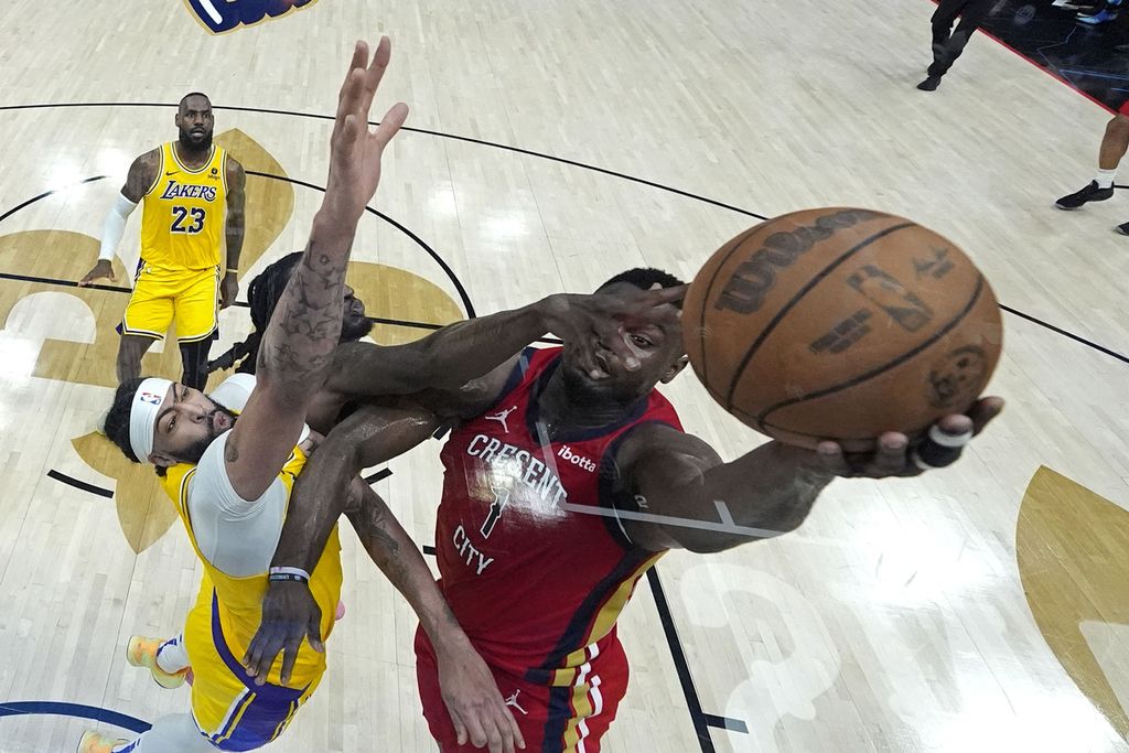 New Orleans Pelicans basketball player, Zion Williamson, tries to put the ball past Los Angeles Lakers basketball players, Anthony Davis and Taurean Prince, during the play-in round match at the Smoothie King Center, New Orleans, Wednesday (17/4/ 2024) WIB.