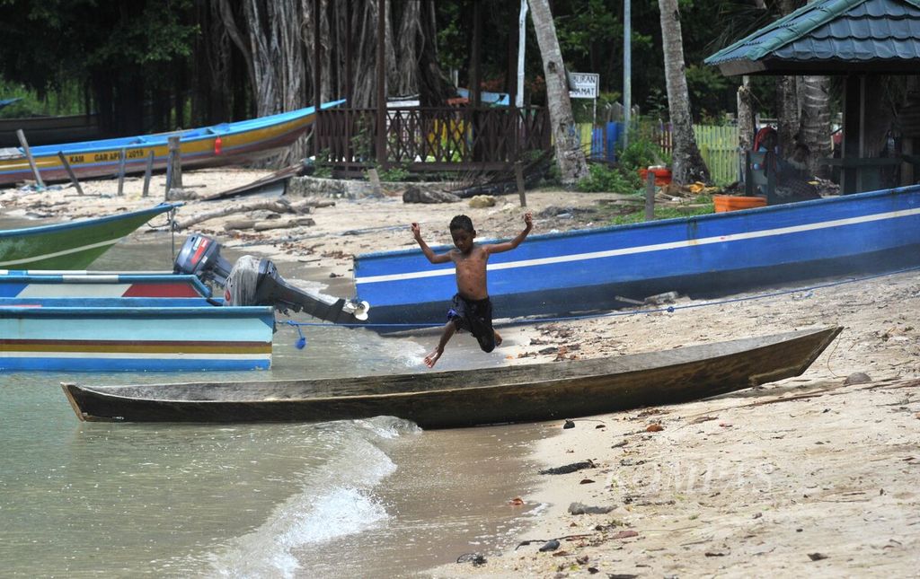 Anak Pulau Ugar yang berada di kawasan konversasi taman perairan Teluk Berau, Distrik Kokas, Kabupaten Fakfak, Papua Barat, bermain di pantai, Minggu (14/5/2023).  