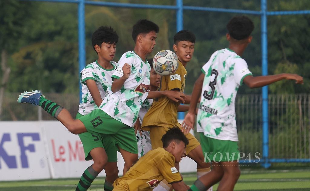 Pemain Intan Soccer Cipta Cendikia, Muchamad Fachri (kiri depan), berusaha menghalau bola yang dikuasai pemain Asiana Soccer School dalam Liga Kompas Kacang Garuda U-14 di Dewantara Sport Center, Tangerang Selatan, Banten, Minggu (3/3/2024). 