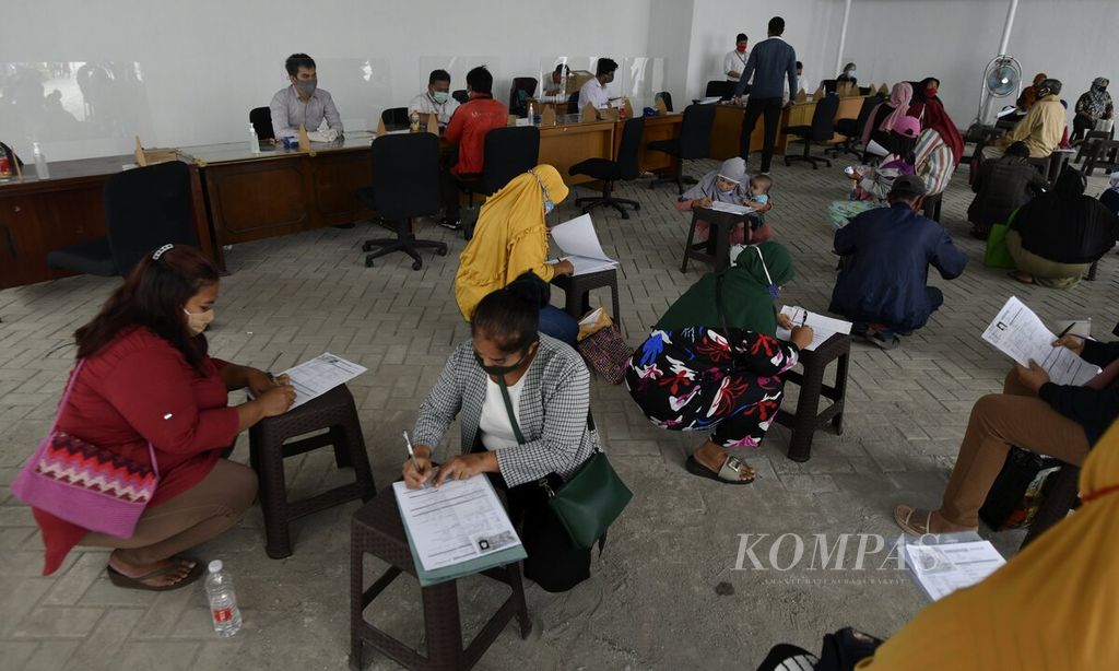 Para orangtua penerima Kartu Jakarta Pintar (KJP) bergiliran mengurus buku rekening dan kartu ATM Bank DKI melalui layanan khusus Bank DKI untuk peserta program KJP di kawasan Matraman, Jakarta Timur, Senin (23/11/2020). 