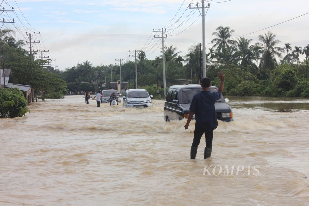 Pengendara menerobos banjir di jalan nasional Desa Alur Memban, Kecamatan Karang Baru, Kabupaten Aceh Tamiang, Aceh, Minggu (6/11/2022). Banjir terjadi sejak Selasa (1/11/2022) menggenangi 146 desa dan memaksa 29.000 warga mengungsi.