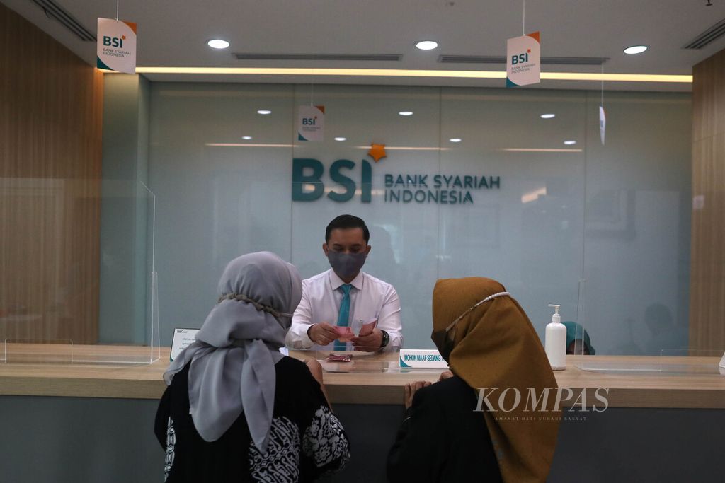 <i>Teller </i>Bank Syariah Indonesia melayani nasabah di Kantor Cabang Hasanudin, Blok M, Jakarta, Senin (1/2/2021). 