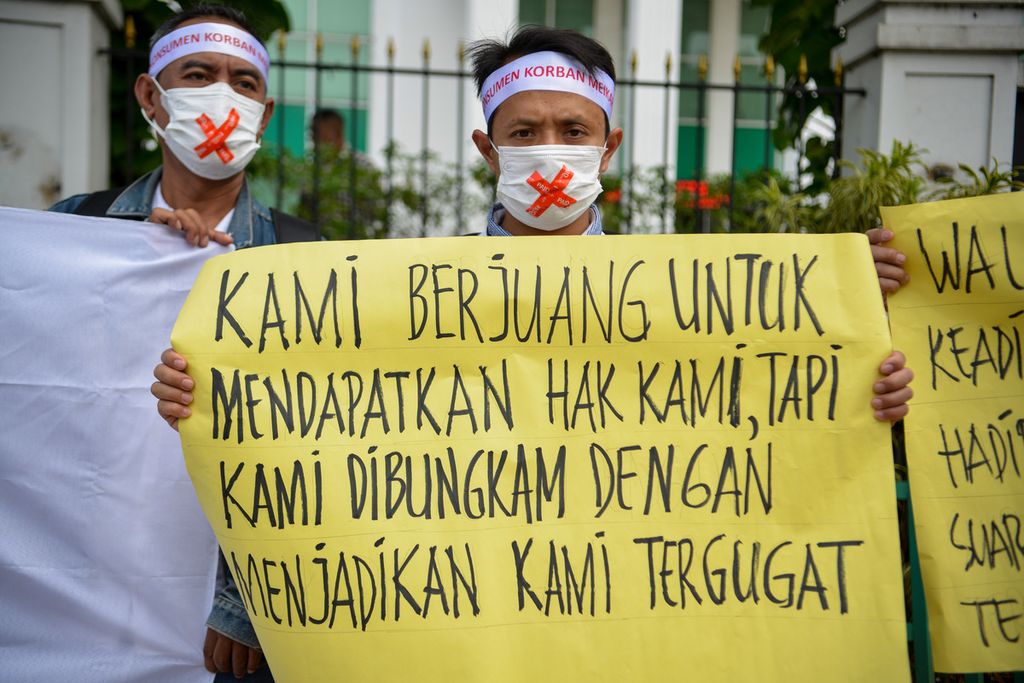Salah satu anggota Perkumpulan Komunitas Peduli Konsumen Meikarta membentangkan spanduk saat melakukan aksi di depan gedung Pengadilan Negeri Jakarta Barat, Selasa (24/1/2023). 