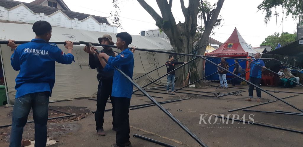 Beberapa sukarelawan mendirikan rangka tenda darurat di halaman RSUD Sayang, Kabupaten Cianjur, Jawa Barat, Sabtu (26/11/2022).