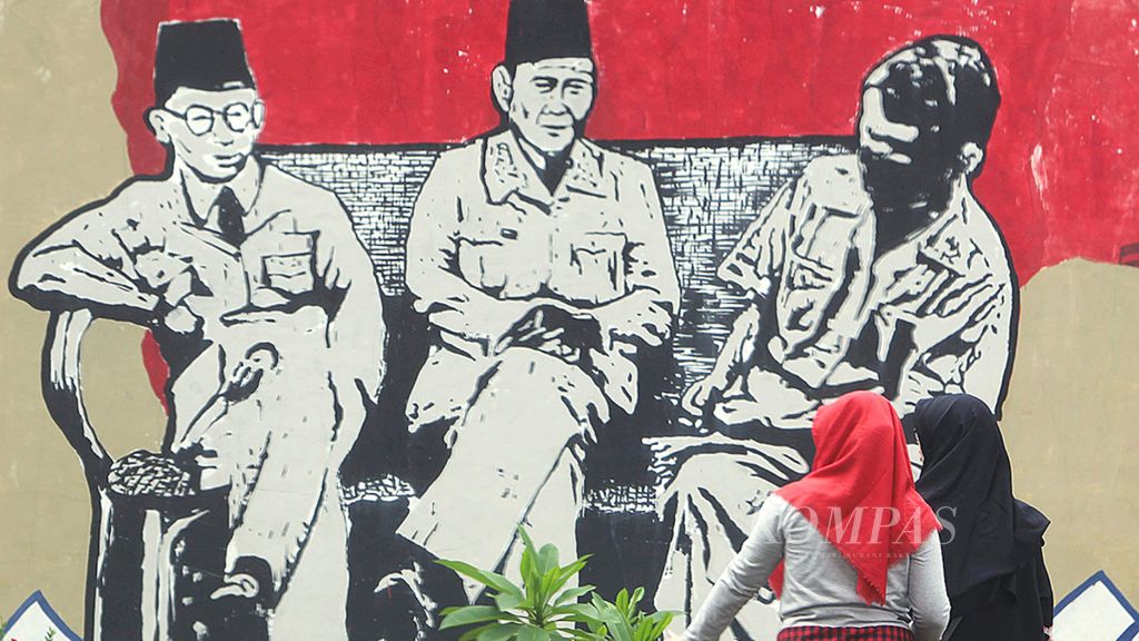 Warga melihat lihat karya mural yang menggambarkan tokoh bangsa Bung Hatta, Bung Karno dan Bung Sjahrir yang di buat di kawasan Kebagusan Pasar Minggu Jakarta, Minggu (21/1/2018).