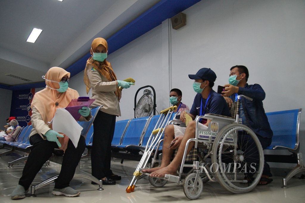 Batam City Class I Port Health Office officers distribute health alert cards to a number of Indonesian migrant workers at Batam Center Port, Batam City, Riau Islands, Tuesday (24/3/2020).