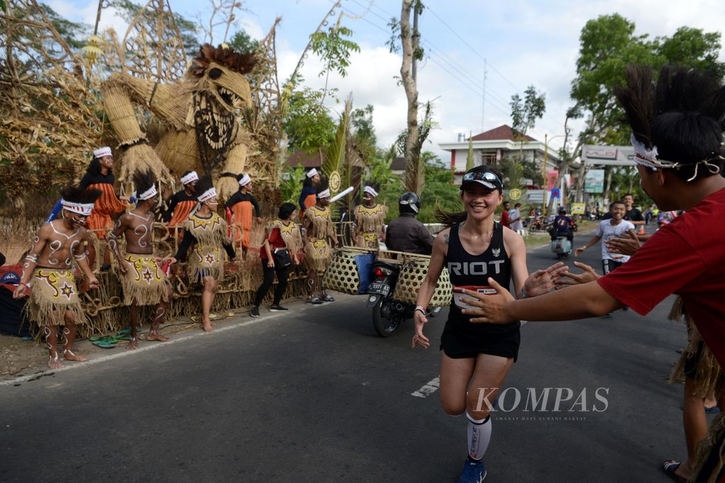 Sejumlah siswa dari Papua menghibur pelari Borobudur Marathon 2019 powered by Bank Jateng yang melintas di Desa Wringinputih, Kecamatan Borobudur, Magelang, Jawa Tengah, Minggu (17/11/2019). Ajang tahunan yang memadukan unsur olahraga, wisata, dan budaya ini disambut antusias oleh pelari dari berbagai daerah dan negara serta masyarakat kawasan Borobudur.