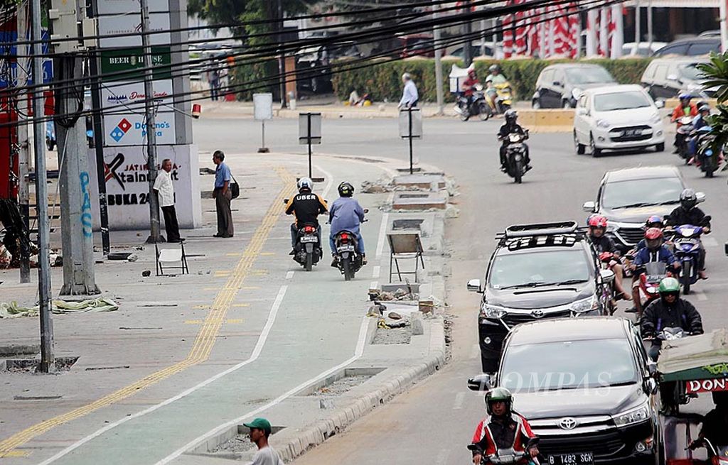 Pengendara motor melintasi jalur sepeda di trotoar Jalan Jatinegara Timur, Jakarta Timur, Kamis (27/7). Trotoar yang telah dilebarkan  tersebut menyediakan jalur khusus bagi pengendara sepeda dan penyandang disabilitas. 
