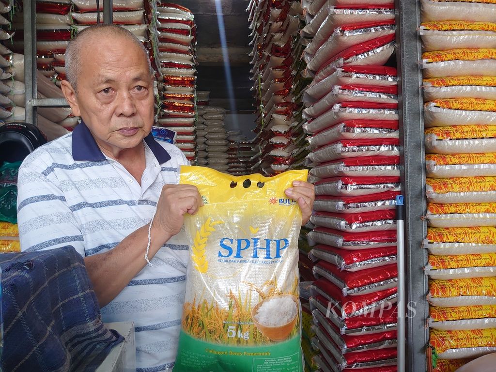 Robert (65), pemilik Toko Beras Tugu Makmur di Pasar Tugu, Kota Bandar Lampung, menunjukkan beras Bulog yang dijual di tokonya pada Senin (11/9/2023). Sejak harga beras naik, masyarakat banyak mencari beras Bulog. 