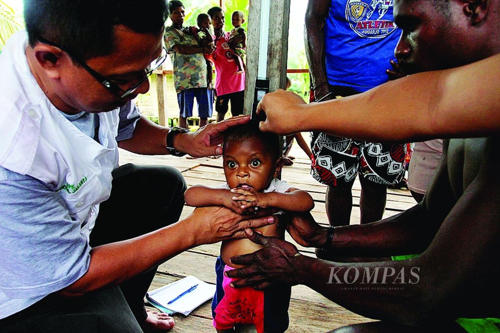 wan Halawani, anggota tim kesehatan dari Kementerian Kesehatan, memberikan pelayanan kesehatan kepada warga di pedalaman Pegunungan Tambrauw, persisnya di Kampung Kwesefo, Distrik Kwoor, Kabupaten Tambrauw, Papua Barat, Minggu (7/4). 