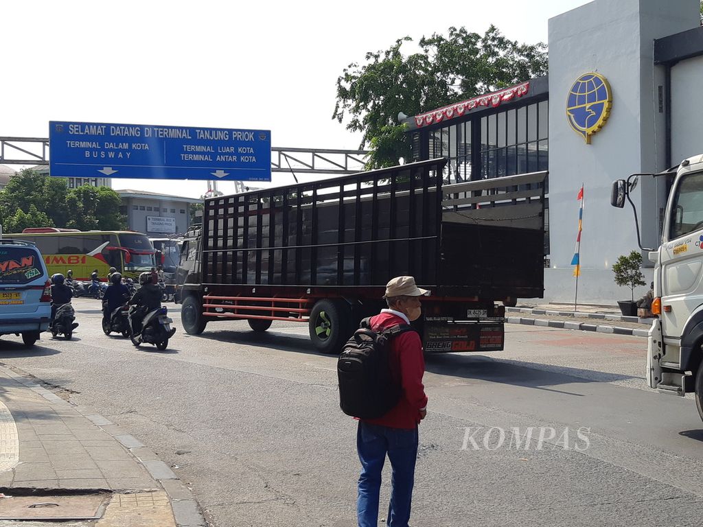 Seorang pejalan kaki bersiap untuk menyeberangi jalan dari depan Stasiun Tanjung Priok ke Terminal Tanjung Priok, Jakarta Utara, pada Senin (7/8/2023) siang. Minimnya rambu lalu lintas di tempat itu membuat pejalan kaki harus ekstra hati-hati.