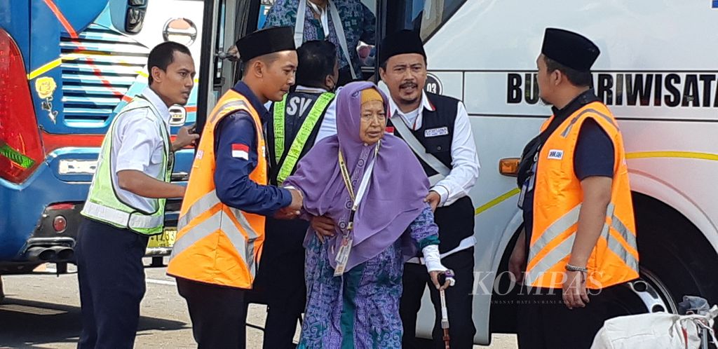 Pendamping lansia memapah jemaah haji lansia. Jemaah haji embarkasi Surabaya kelompok terbang pertama berjalan menuju pesawat Saudi Arabia, Rabu (24/5/2023). Mereka berasal dari Bangkalan, Jatim.