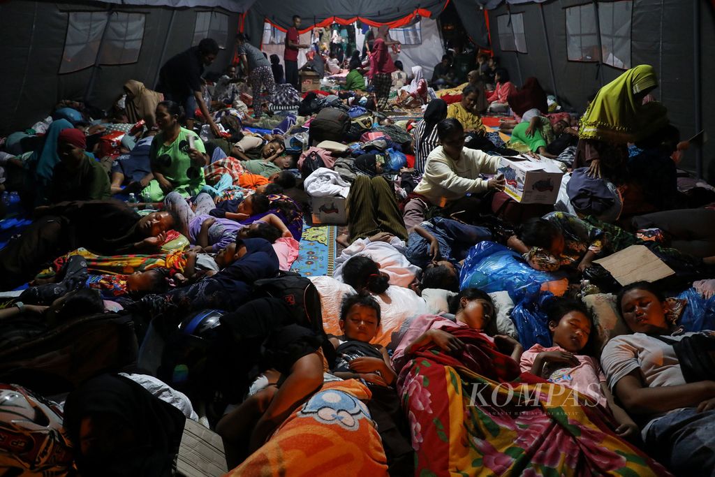 Pengungsi beristirahat di tenda yang didirikan di halaman Kantor Bupati Pasaman Barat, Pasaman Barat, Sumatera Barat, Sabtu (26/2/2022) malam. Mereka merupakan warga korban gempa bermagnitudo 6,1 dari sejumlah tempat di Pasaman Barat.