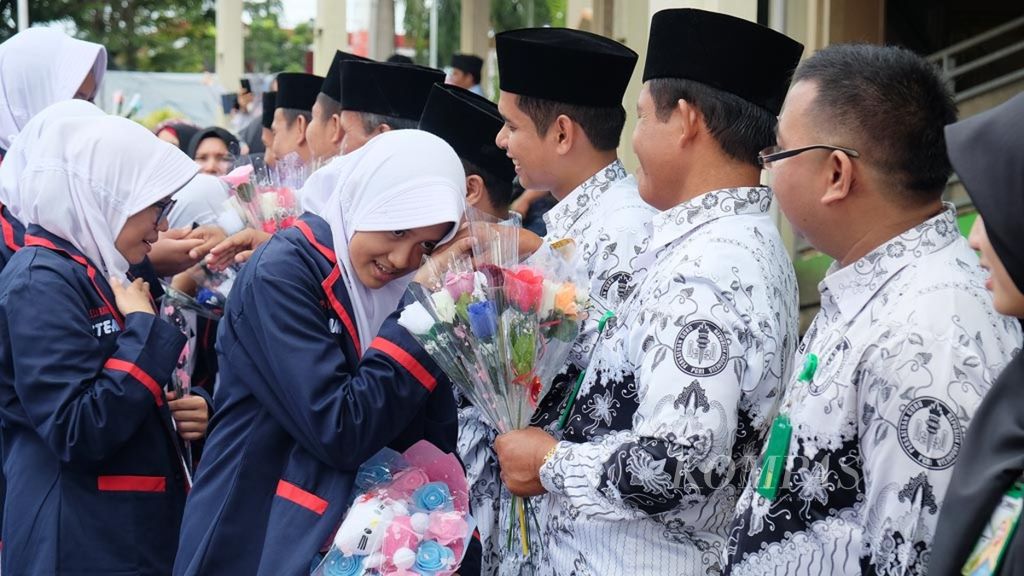 Para siswa Sekolah Dasar Islam Al-Azhar 32 Padang, Sumatera Barat, bersalaman dengan guru mereka seusai upacara peringatan hari guru nasional, Senin (26/11/2018).