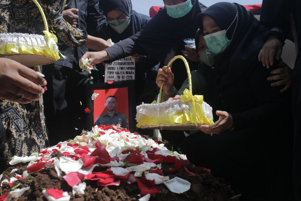 Sejumlah anggota keluarga Sersan Satu Anumerta Muhammad Rizal Maulana Arifin menaburkan bunga seusai pemakamannya di Taman Makam Pahlawan Cikutra, Kota Bandung, Jawa Barat, Sabtu (29/1/2022).