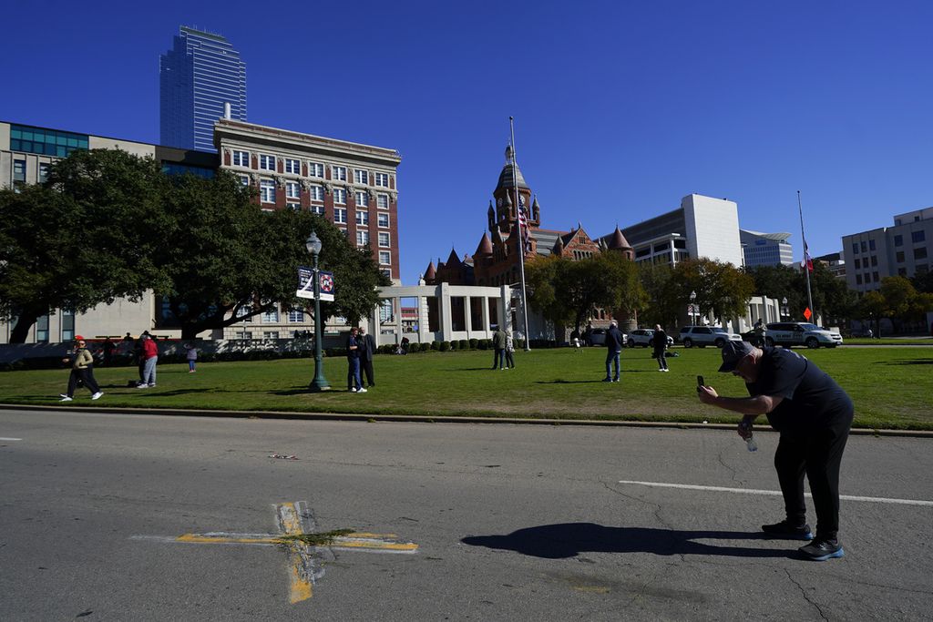 Seseorang memotret tanda huruf X dengan ponsel di Elm Street di Dealey Plaza di Dallas, salah satu dari dua tempat yang ditandai di mana Presiden John F. Kennedy ditembak, saat orang-orang berkumpul pada peringatan 60 tahun pembunuhannya, Rabu (22/11/2023). AP Photo/Julio Cortez 22-11-2023 