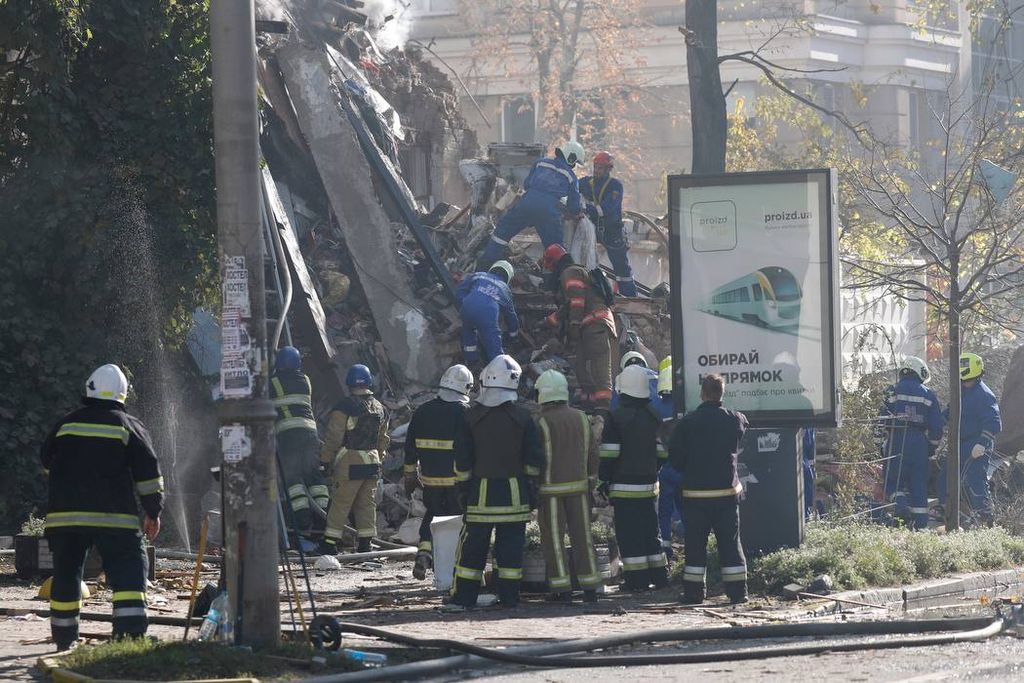 Petugas gawat darurat Kyiv, Ukraina, mengevakuasi korban di salah satu gedung yang meledak pada Senin (17/10/2022) dini hari. Gedung itu salah satu sasaran pesawat nirawak berpeledak yang diarahkan Rusia ke sejumlah kota di Ukraina.