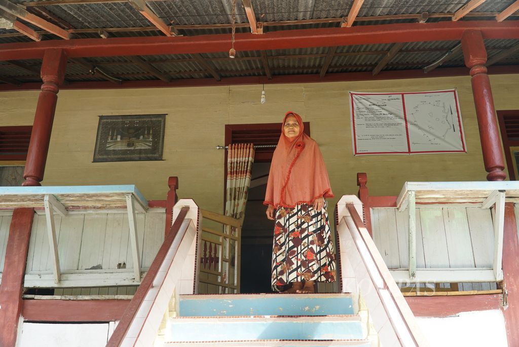 Zumratul Aini (67), salah satu pewaris Rumah Gadang Kajang Padati milik suku Tanjuang di Kelurahan Seberang Palinggam, Kecamatan Padang Selatan, Kota Padang, Sumatera Barat, berpose di depan rumahnya, Kamis (13/10/2022). 
