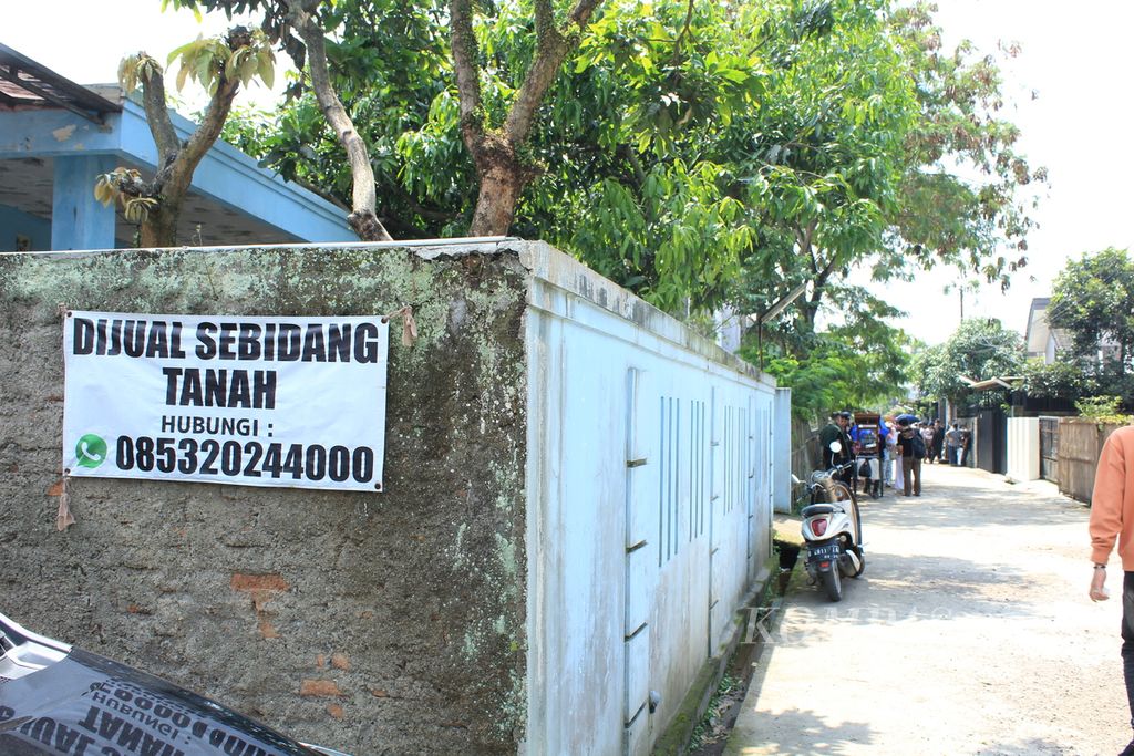 Spanduk penawaran sebidang tanah yang hendak dijual di Kampung Ciganitri, Kecamatan Bojongsoang, Kabupaten Bandung, Jawa Barat, Minggu (19/3/2023). Kawasan ini dulu dikenal sebagai rawa dan persawahan. Mulai tahun 2000-an, perumahan mulai menjamur dan sebagian warga memilih menjual tanahnya.