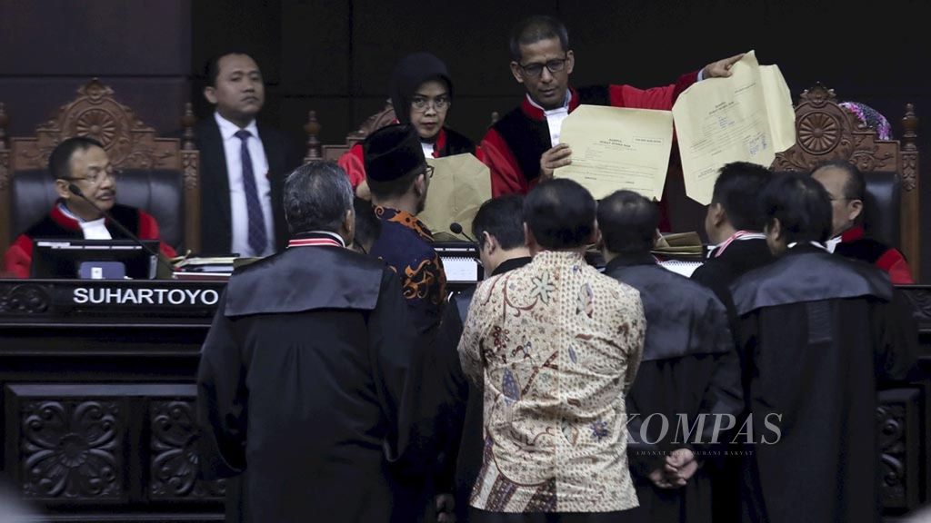 Pihak termohon, KPU, menunjukkan dan menyerahkan alat bukti kepada hakim MK saat sidang sengketa perselisihan hasil pemilu Pilpres 2019 di Mahkamah Konstitusi, Jakarta, Kamis (20/6/2019).
