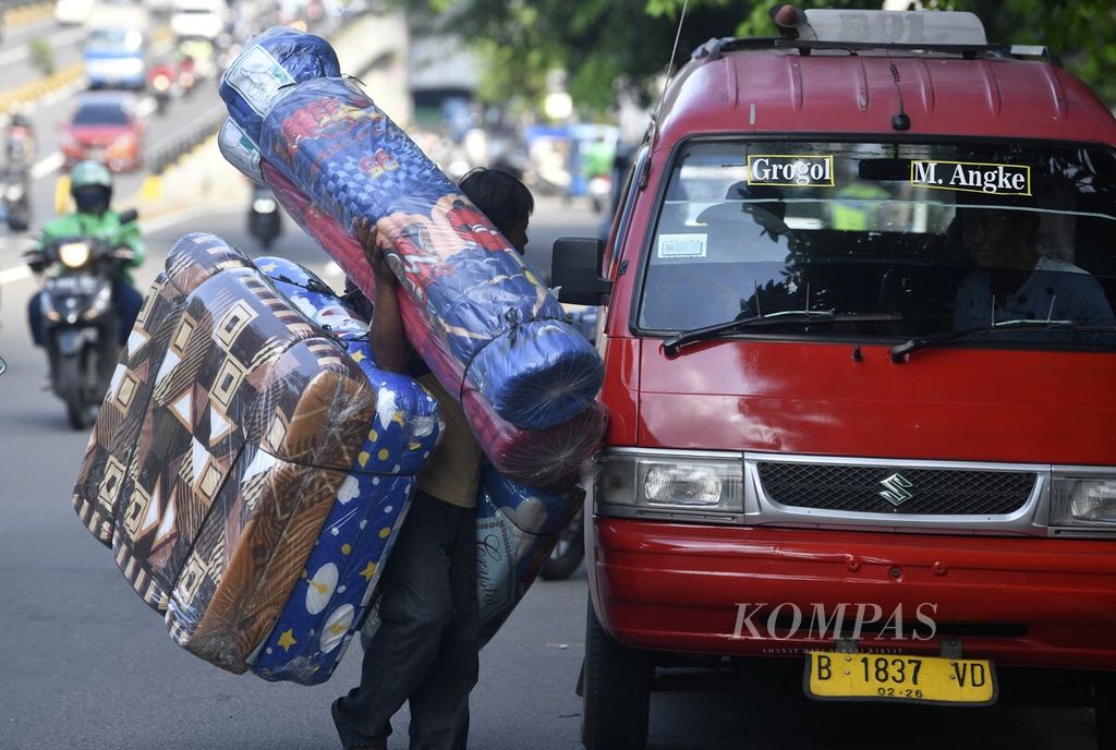 Penjual kasur keliling membawa dagangan berkeliling di kawasan Grogol, Jakarta Barat, Rabu (8/12/2021). 
