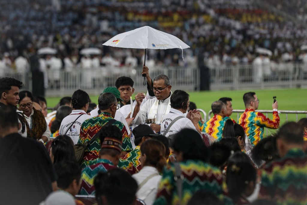 Umat Nasrani mendapatkan hosti saat mengikuti misa akbar bersama Paus Fransiskus di Stadion Gelora Bung Karno (GBK), Jakarta, dengan kendaraan terbuka Kamis (5/9/2024).