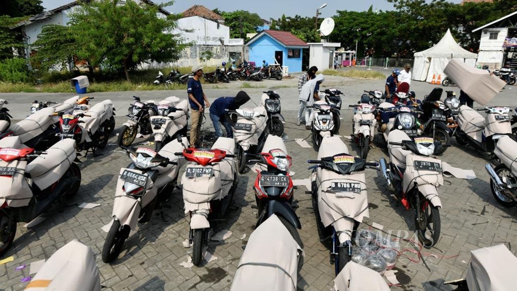 Pekerja menyiapkan sepeda motor warga yang mengikuti angkutan mudik gratis sepeda motor di Stasiun Jakarta Gudang, Jakarta (26/5/2019), Mudik gratis sepeda motor menjadi salah satu upaya pemerintah untuk mengurangi penggunaan sepeda motor saat mudik yang kerap menyebabkan kecelakaan.