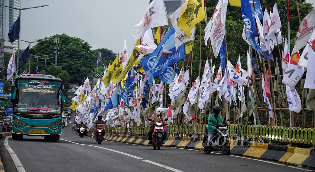 Deretan bendera partai politik terlihat masih terpasang di tepian tembok Jembatan Layang Senayan, Jakarta, Rabu (31/1/2024). Selain baliho dan spanduk, bendera parpol yang terpasang secara serampangan di tepi jalan juga membahayakan pengendara kendaraan di jalan tersebut 