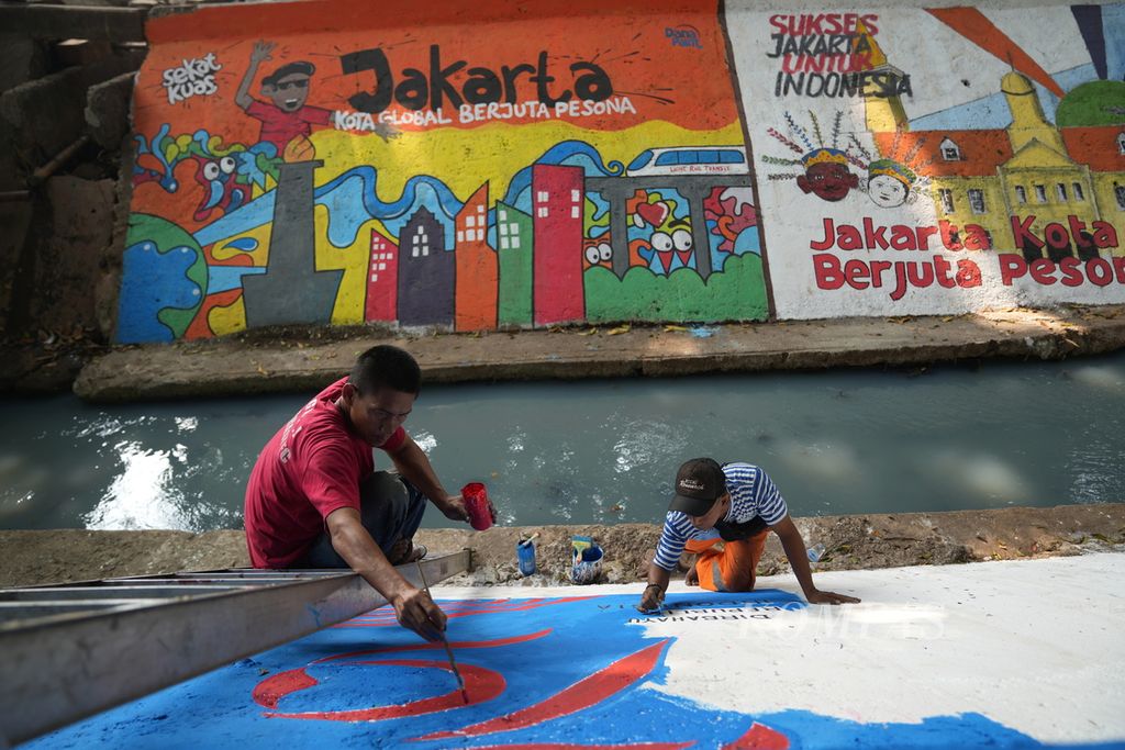 Petugas Penanganan Prasarana dan Sarana Umum Kelurahan Penggilingan menyelesaikan mural memeriahkan HUT Ke-79 RI bertema Jakarta Kota Global Berjuta Pesona di dinding Kali Taman Lansia Penggilingan, Cakung, Jakarta Timur, Rabu (21/8/2024).