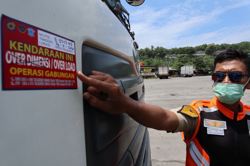 Petugas menunjukkan stiker penanda kendaraan melanggar batas muatan dalan operasi "over dimention over load" di Kilometer 208 Jalan Tol Palimanan -Kanci, Kabupaten Cirebon, Jawa Barat, Rabu (26/2/2020).