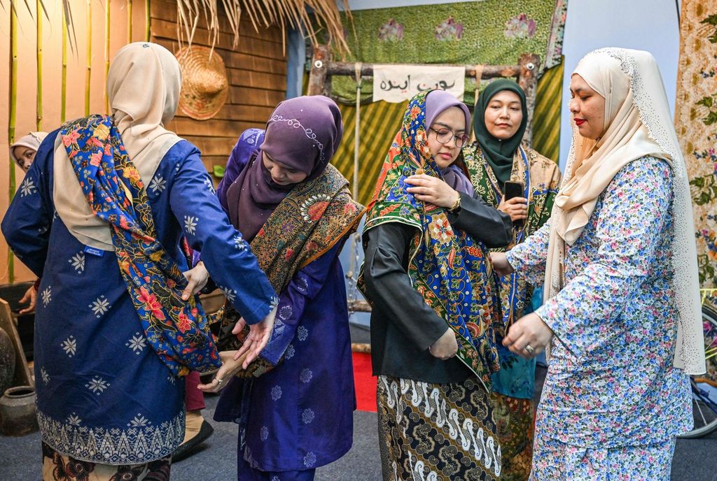 Beberapa perempuan Malaysia memakai baju tradisional, baju kurung dan batik, saat akan menjalani sesi foto menjelang perayaan Idul Fitri di sebuah kantor di Kuantan, Negara Bagian Pahang, Malaysia, 3 April 2024. 
