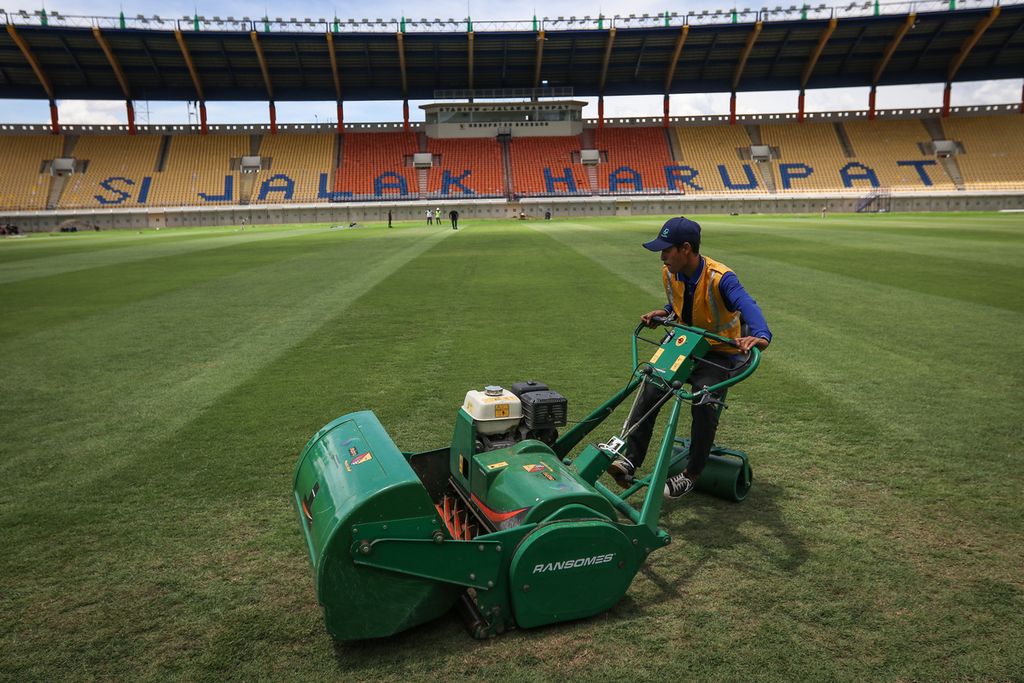 Seorang pekerja memotong rumput di Stadion Si Jalak Harupat, Kabupaten Bandung, Senin (3/4/2023). Perbaikan Stadion Si Jalak Harupat tetap berlanjut meski Indonesia batal menjadi tuan rumah Piala Dunia U-20. Proses renovasi stadion tersebut telah memasuki tahap akhir. 