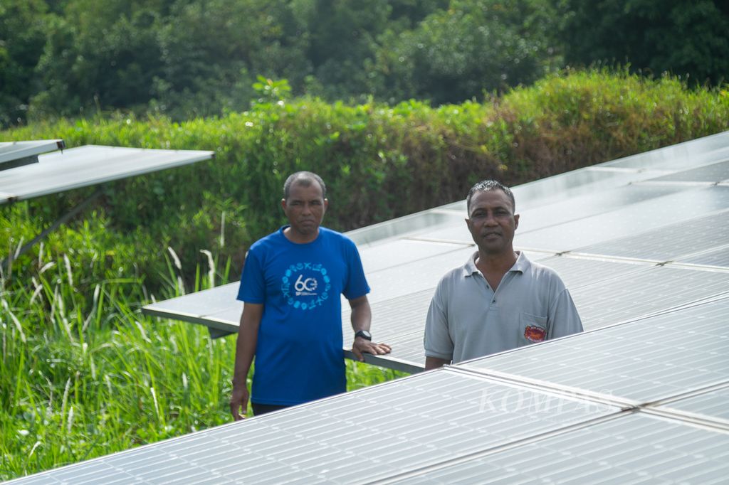 Mustofa (kanan) dan Karim menunjukkan panel surya yang dipasang di Pulau Mecan, Kota Batam, Kepulauan Riau, Selasa (12/12/2023).