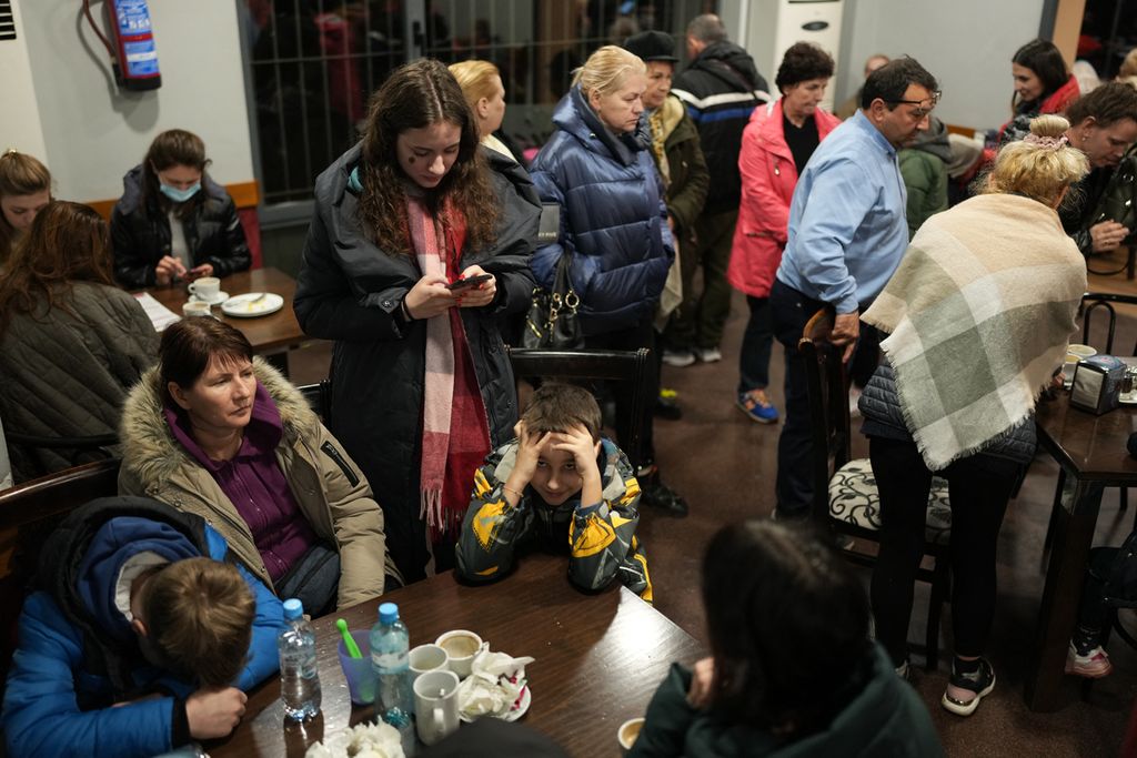 Pengungsi Ukraina yang dibawa oleh konvoi sopir taksi Spanyol, beristirahat saat berhenti di sebuah restoran pinggir jalan di Burgos, Spanyol, Rabu (16/3/2022). Rombongan tersebut menuju Polandia dari Madrid setelah berhasil keluar dari Ukraina.