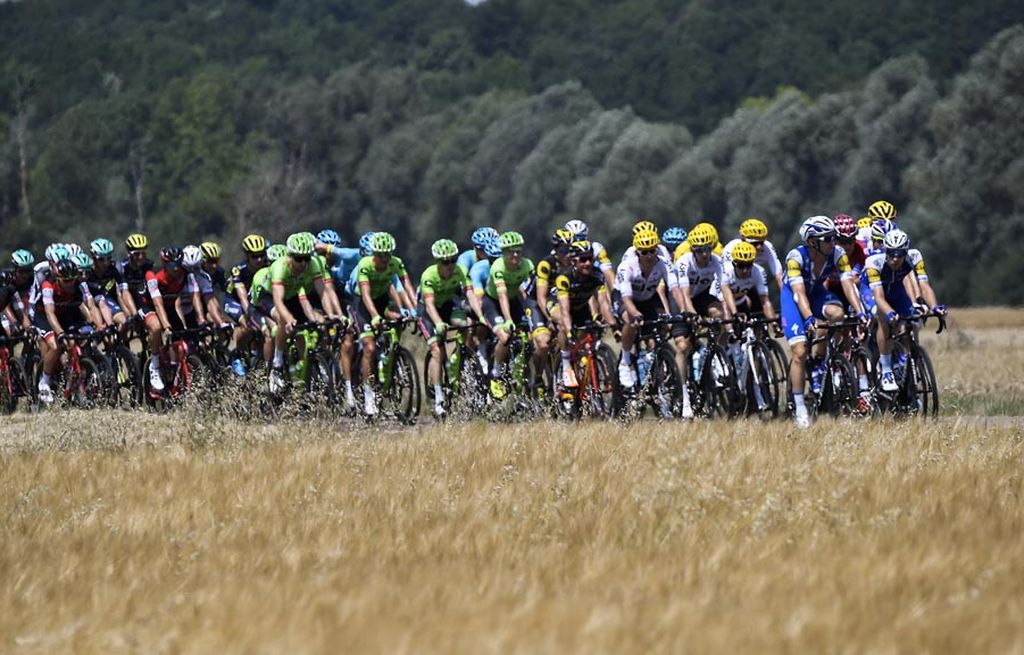 Rombongan pebalap  peserta lomba balap sepeda Tour de France melintasi ladang pada etape ketujuh yang menempuh jarak 213,5 kilometer dari Troyes hingga Nuits-Saint-Georges, Perancis, Jumat (7/7). Jalur yang sebagian besar tanjakan landai dan lintasan datar itu menjadi ajang persaingan  para sprinter.